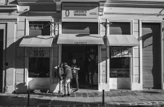 Black and white photo of an urban street scene featuring a storefront facade.