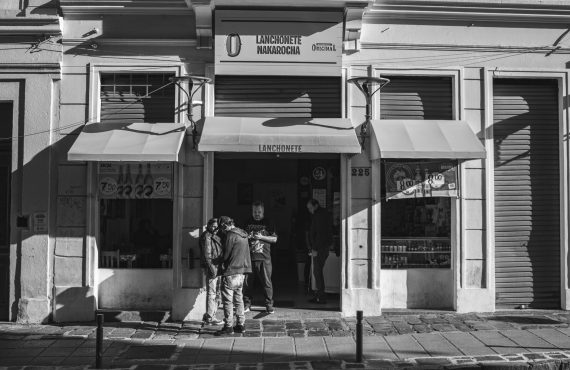 Black and white photo of an urban street scene featuring a storefront facade.