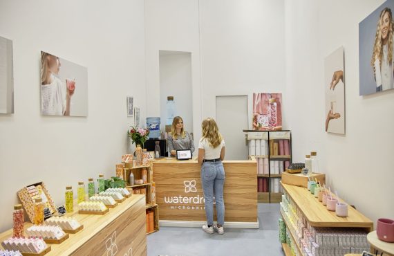 Aquatic-themed store interior with vibrant products and a customer at the counter, Berlin.