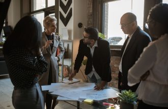 Group of diverse professionals discussing project plans in a well-lit office.