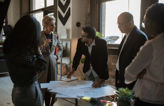 Group of diverse professionals discussing project plans in a well-lit office.