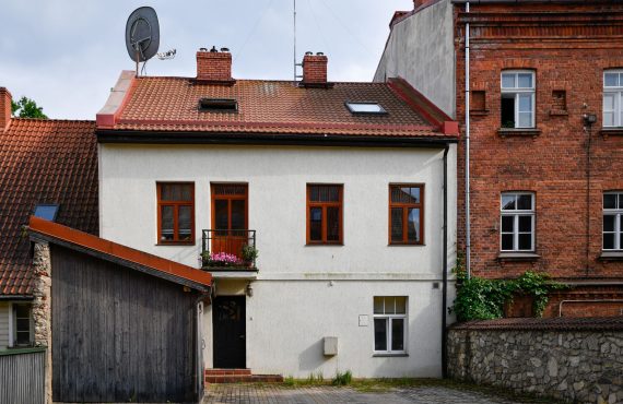 A cozy and charming residential house with traditional architecture in Latvia, showcasing a peaceful suburban scene.